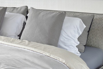 Pillows setting on bed with gray color scheme bedding