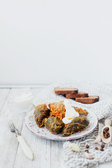 
National traditional Ukrainian and Russian cuisine , a dish called cabbage rolls , stewed rice with minced meat in cabbage leaves with sour cream , carrots and spices on a wooden background