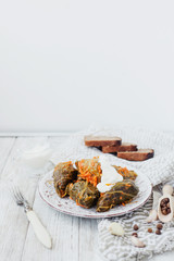 
National traditional Ukrainian and Russian cuisine , a dish called cabbage rolls , stewed rice with minced meat in cabbage leaves with sour cream , carrots and spices on a wooden background