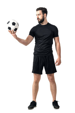 Determined challenging confident soccer player looking at the ball. Full body length portrait isolated over white background.