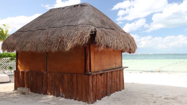Tropical wooden hut with palm leafs roof on caribbean sea shore
