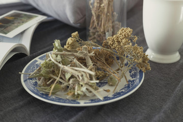 Mix of dried herbs over plate to make a tea on a warm spring afternoon while reading
