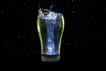 Colored glass of water with a water drops