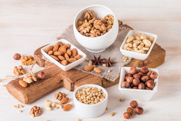 almonds, walnuts, hazelnuts cashews and pine nuts in wooden bowl