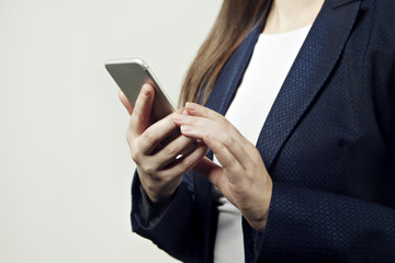 Close-up of woman hands hold phone, woman wears suit