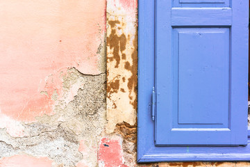 Blue window shutter on old shabby pink wall