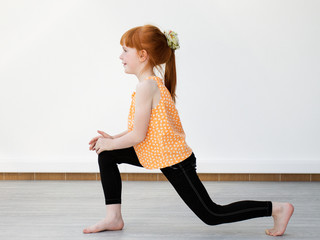 Little girl doing squat and smiling