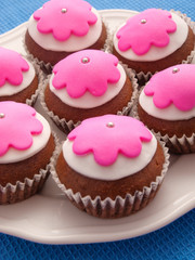 Glazed cupcakes with white and purple glazing on white plate