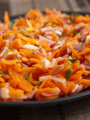 Healthy salad from grated carrots, ham and dressing. Close up, low angle view