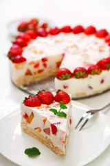 Cake with strawberries, gelly yogurt and cherries. Surface view. Isolated on white background. One piece in a white plate. Vertical shot