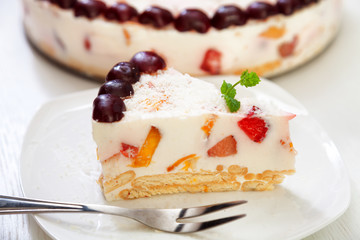 Cake with cherris, gelly yogurt and fruits. Isolated on white background. One piece in a white plate. Horizonta; shot
