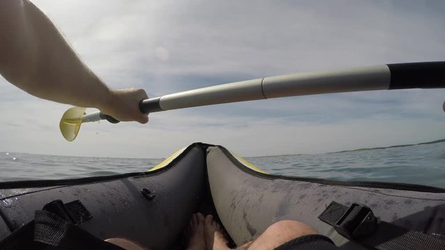 Kayaker paddling on sea