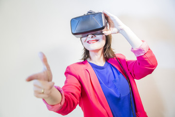 happy smiling young beautiful girl l getting experience using VR-headset glasses of virtual reality with a gesture pointing his finger forward