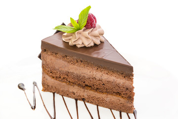 Prague piece of cake decorated with raspberries on a white background