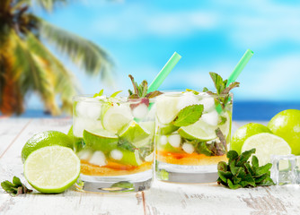 Mojito lime drink on wood with blur beach background