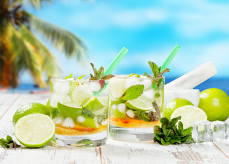 Mojito lime drink on wood with blur beach background