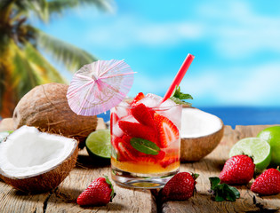 Strawberry drink on wood with blur beach background