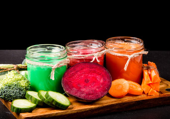 Fresh green, beetroot and carrot smoothie in the glass on black stone. Lifestyle concept