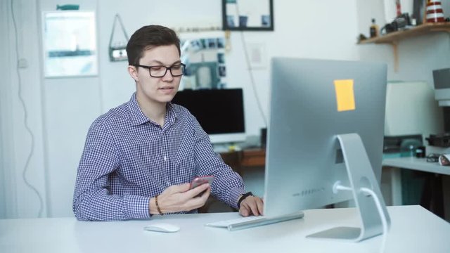 oung man working from home using smart phone and notebook computer