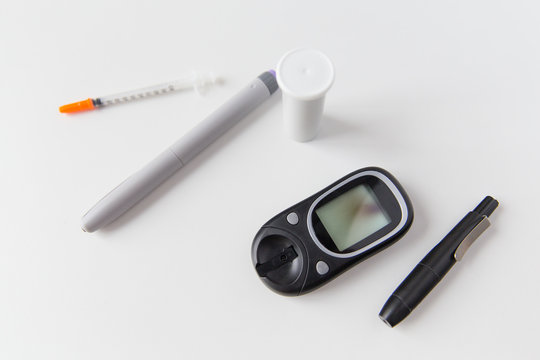 close up of glucometer, insulin pen and syringe