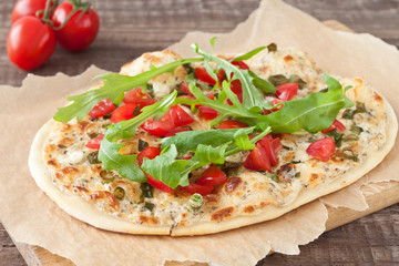 Tarte flambee, an alsatian pizza, with tomatoes and arugula