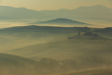 Misty sunrise in the Val d’Orcia, or Valdorcia, a region of Tuscany, central Italy, which extends from the hills south of Siena to Monte Amiata. 