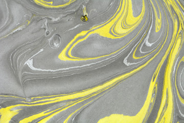 Abstract background. Ink marbling texture. Grey, yellow and white. Hand drawn marble illustration, ebru aqua paper and silk print. Traditional Turkish ebru technique. Painting on water. 