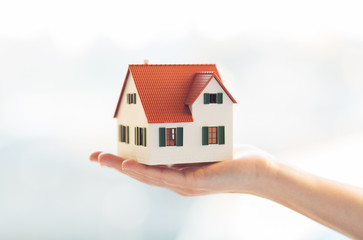 close up of hands holding house or home model