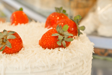 Close up of creamy, delicious strawberry cake on a blurry background