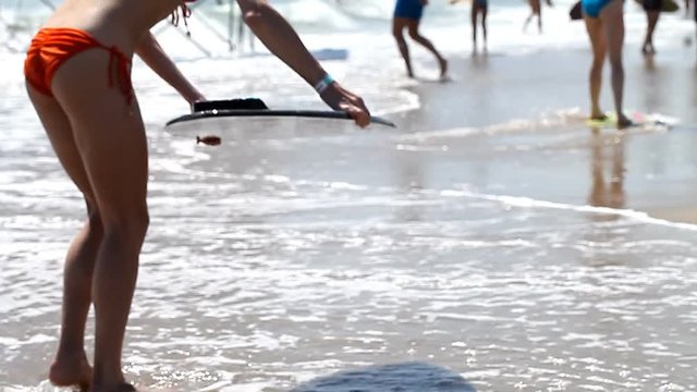 Beautiful slim girl ride on skimboards