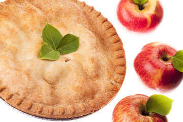 apple pie displayed with apples on side.