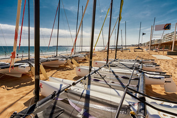 Catamaran empty. Catamaran stored on beach in La Baule France on blue sky.