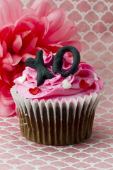 view of a strawberry cupcake with alphabets and flowers.