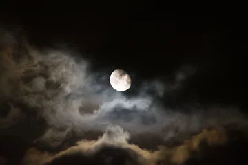 Zelfklevend Fotobehang moon surrounded by dark clouds at night © Gabriele Maltinti