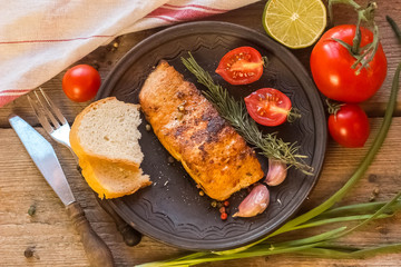 fresh raw salmon steaks with salt, peppers, lemon, tomatoes and dill on the rustic table