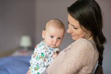 Young mother holding her cute baby daughter