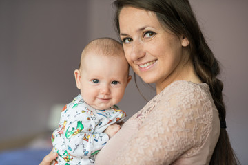 Young mother holding her cute baby daughter