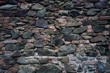 Stone old wall texture. Old rock blocks in old medieval brick. Exterior historical country situation with fencing. Village rural foundation background.