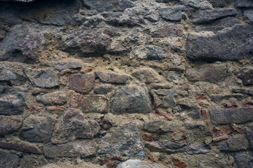 Stone wall texture. Old rock blocks in old medieval brick. Exterior historical country situation with fencing. Village rural foundation background. Graphic texture element.