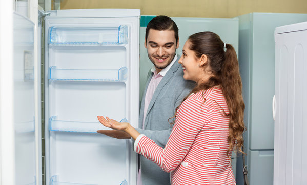 Satisfied customers looking at large fridges