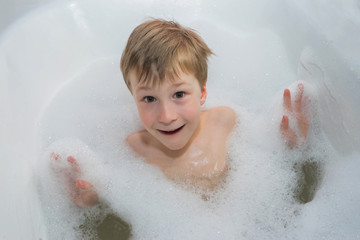 Fototapeta premium Little happy boy in foam soap in the bathroom .