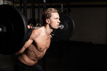Fototapeta na wymiar Fit man in gym lifting weights