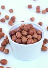 Hazelnuts in the bowl on the white background