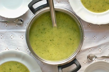 Soup from zucchini in the pot and plates