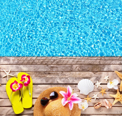 Beach accessories on wooden background with pool