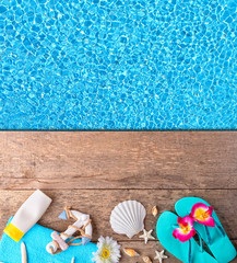 Beach accessories on wooden background with pool