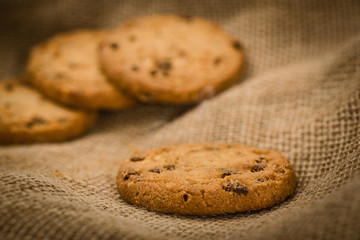 Christmas cookies on a wooden table covered in jute. Horizontal concept image for holiday background.