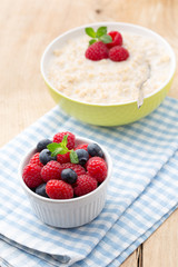 Oatmeal porridge in bowl with berries raspberries and blackberri