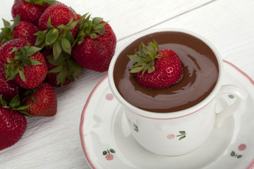 strawberry dipped in cup of melted chocolate