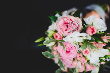 Pair or wedding rings on bouquet flower, focus on diamonds